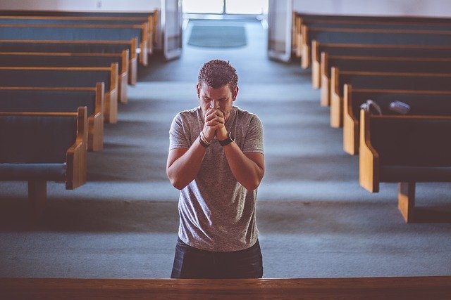 man praying for protection of evil and good
